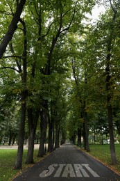 Beautiful view of pathway with word Start in park on autumn day