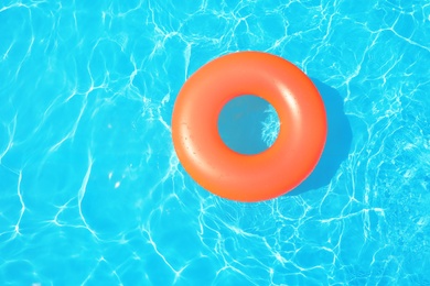 Photo of Inflatable ring floating in swimming pool on sunny day, top view
