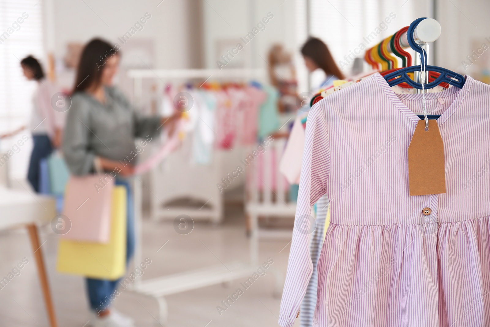 Photo of Baby clothes hanging on rack in store. Shopping concept