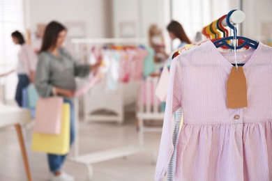 Photo of Baby clothes hanging on rack in store. Shopping concept