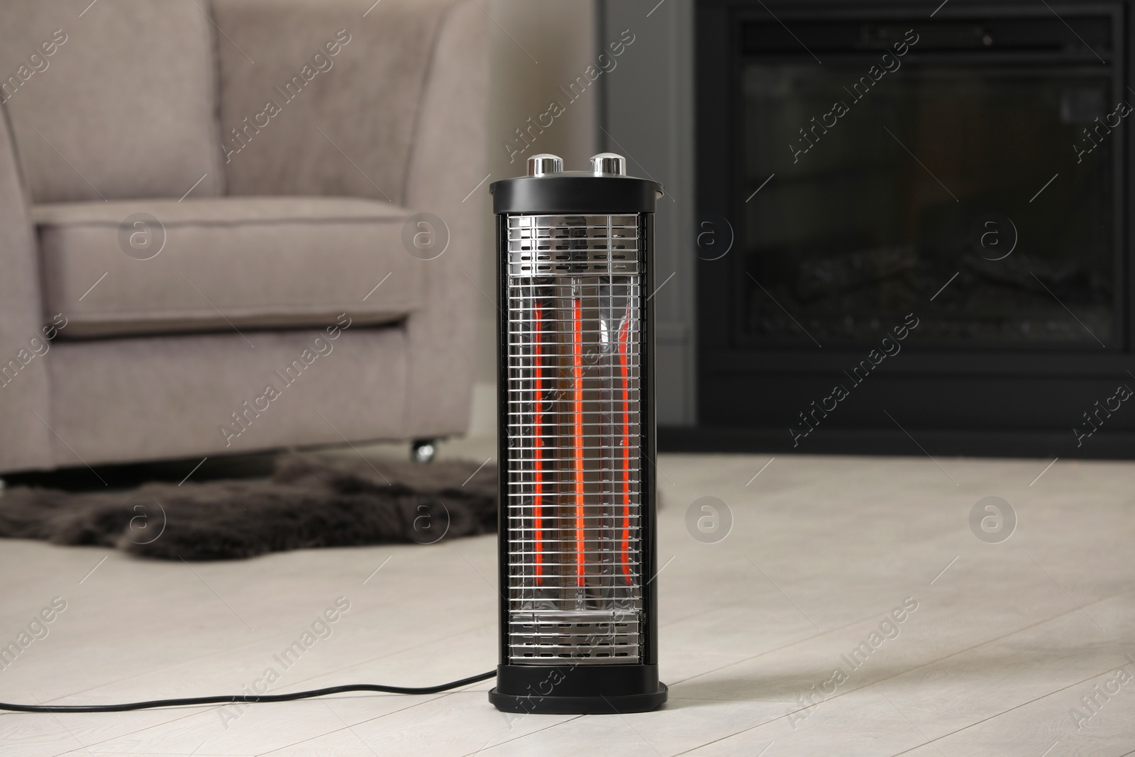 Photo of Modern infrared heater on white wooden floor in cozy room