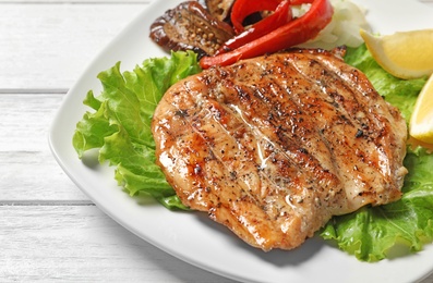 Photo of Plate with tasty grilled meat and vegetables on table, closeup