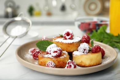 Delicious cottage cheese pancakes with fresh raspberries, mint and icing sugar on white table