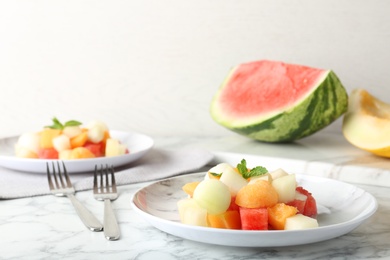 Photo of Salad with watermelon and melon on marble table