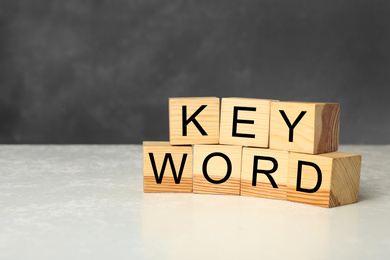 Photo of Wooden cubes with word KEYWORD on white table