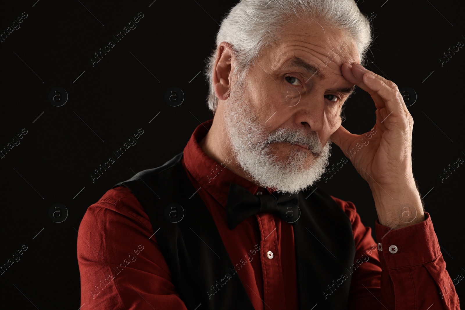 Photo of Senior man touching mustache on black background