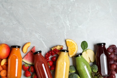 Bottles of delicious juices and fresh fruits on marble table, flat lay. Space for text