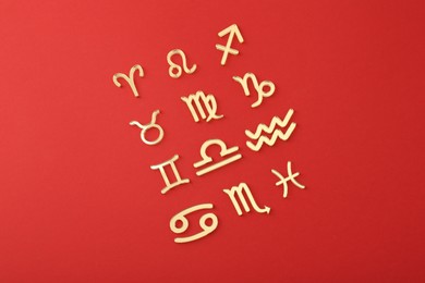 Photo of Zodiac signs on red background, flat lay