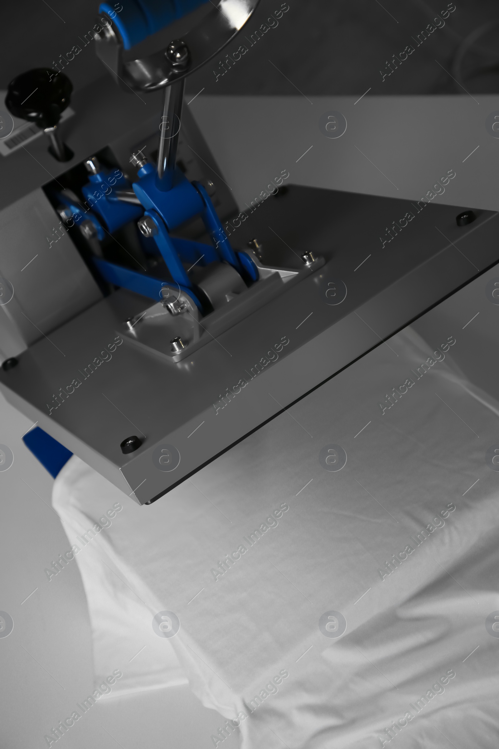 Photo of Printing logo. Heat press with t-shirt on white table