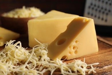 Photo of Grated and cut cheese on wooden board, closeup