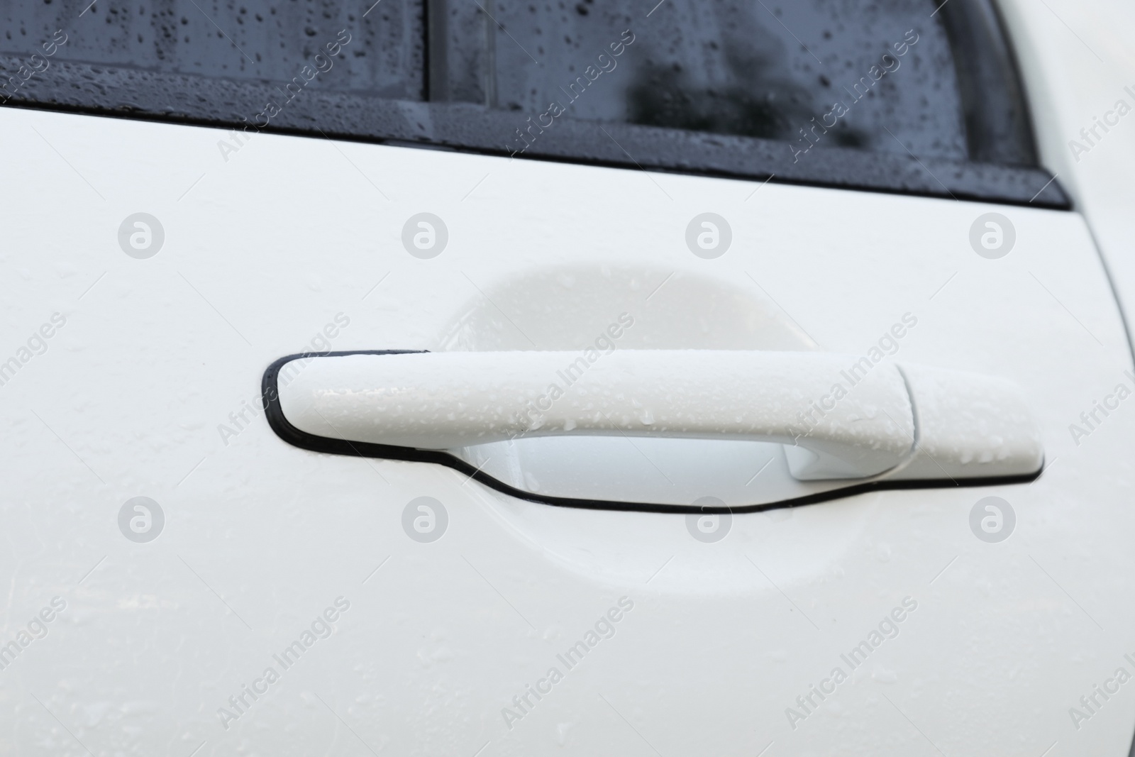 Photo of Closeup view of car door handle with water drops