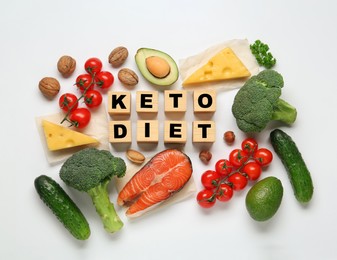 Photo of Wooden cubes with phrase Keto Diet and different fresh products on white background, flat lay