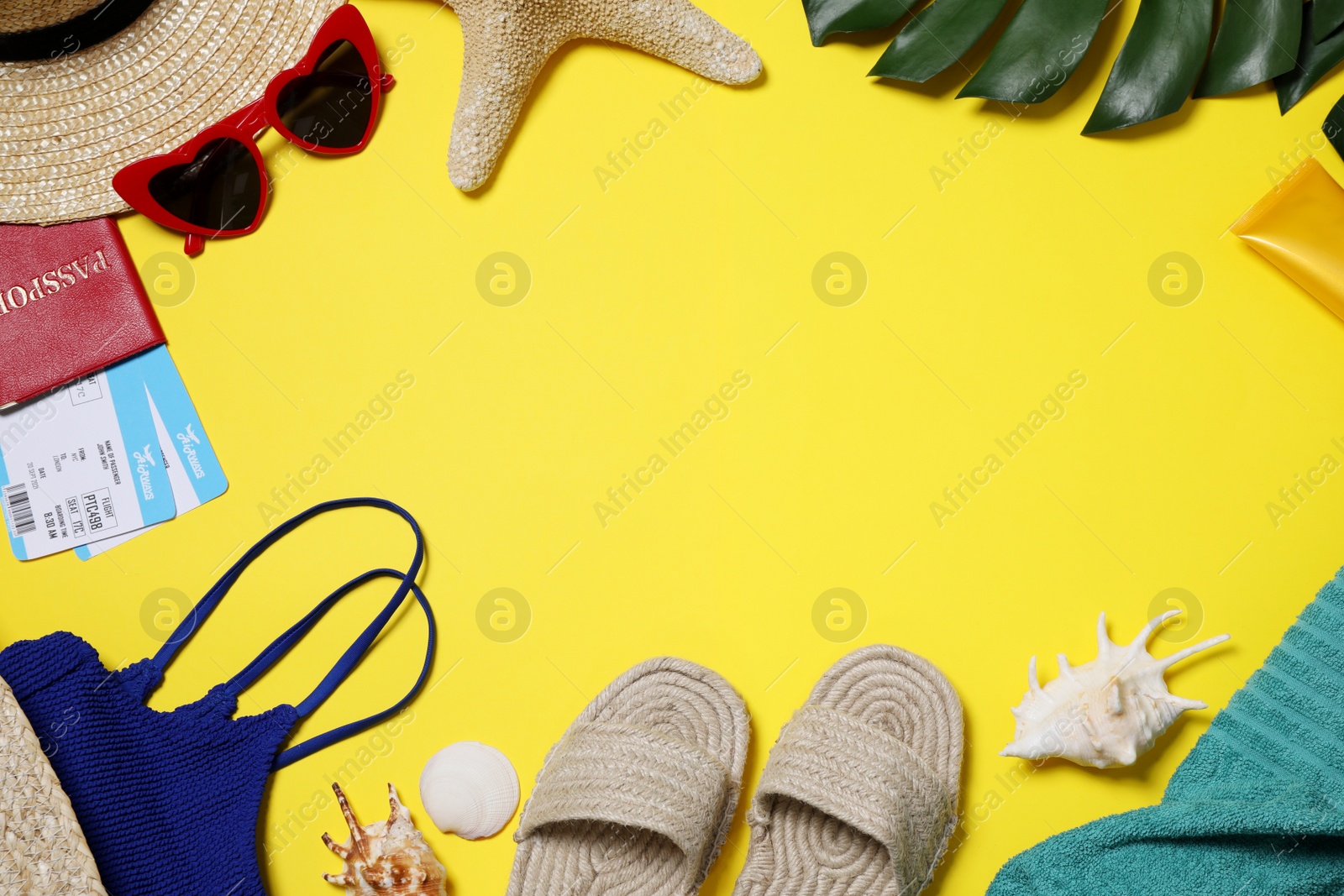 Photo of Flat lay composition with beach accessories on yellow background. Space for text