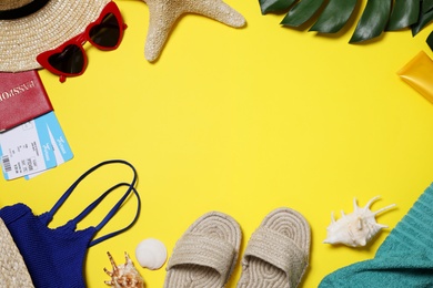 Flat lay composition with beach accessories on yellow background. Space for text