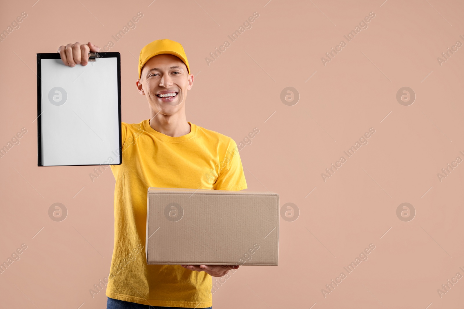 Photo of Happy courier with parcel and clipboard on beige background. Space for text