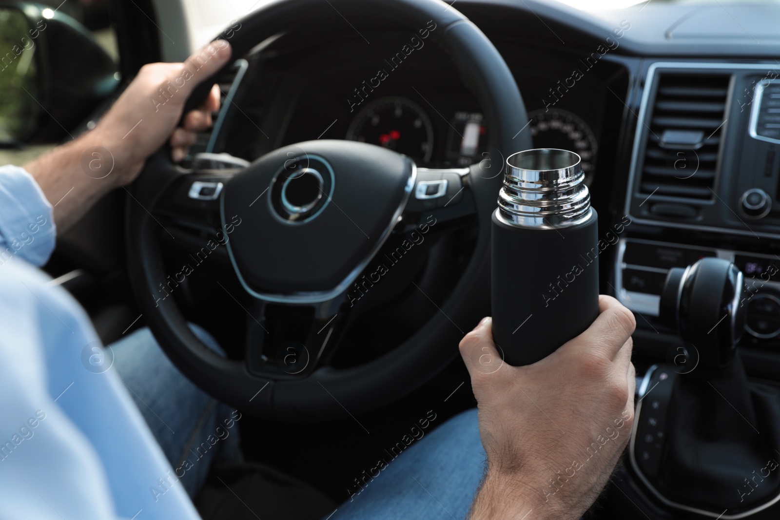 Photo of Man with thermos driving car, closeup view