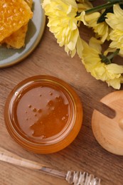 Photo of Flat lay composition with sweet golden honey in jar and chrysanthemum flowers on wooden table