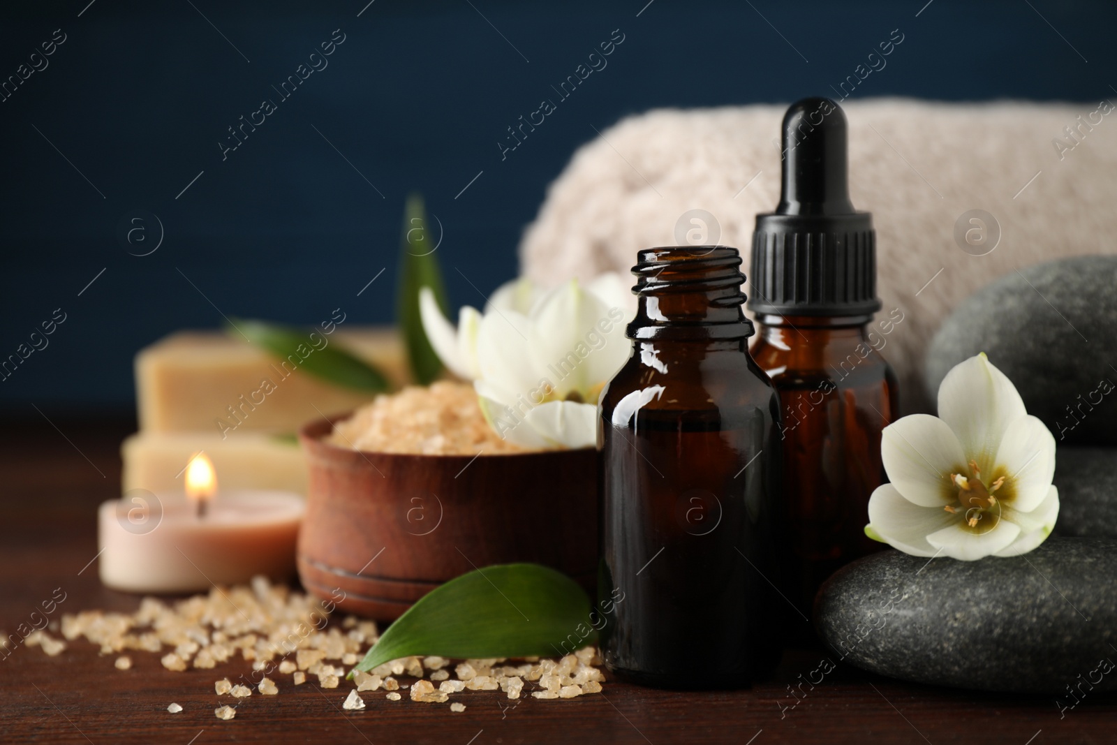 Photo of Closeup composition with skin care products, aroma oil and spa stones on wooden table. Space for text