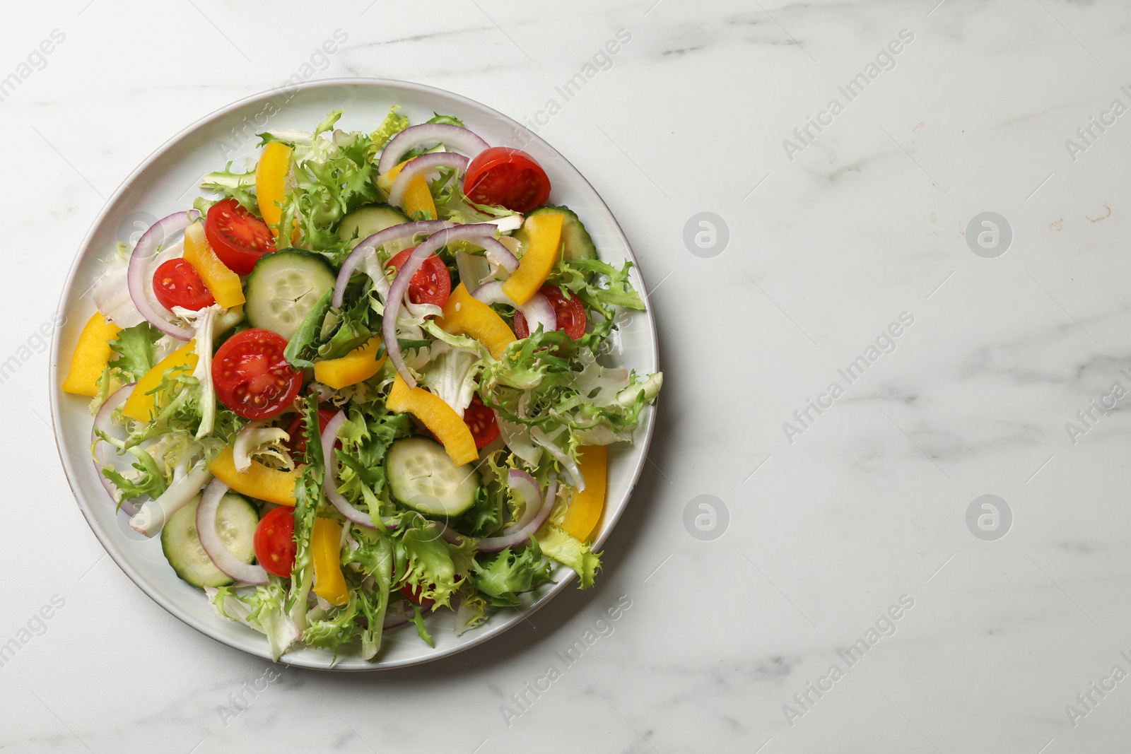 Photo of Tasty fresh vegetarian salad on white marble table, top view. Space for text