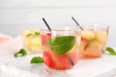 Glasses with tasty watermelon and melon ball drink on table