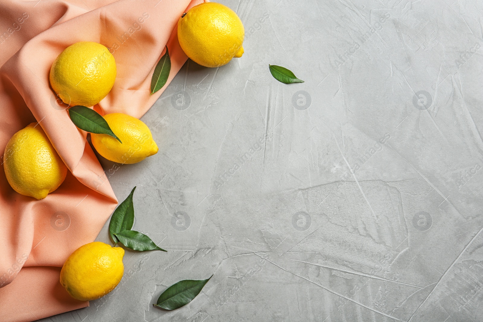 Photo of Flat lay composition with lemons, leaves and fabric on light background