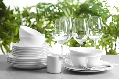 Photo of Set of clean dishes on blurred background