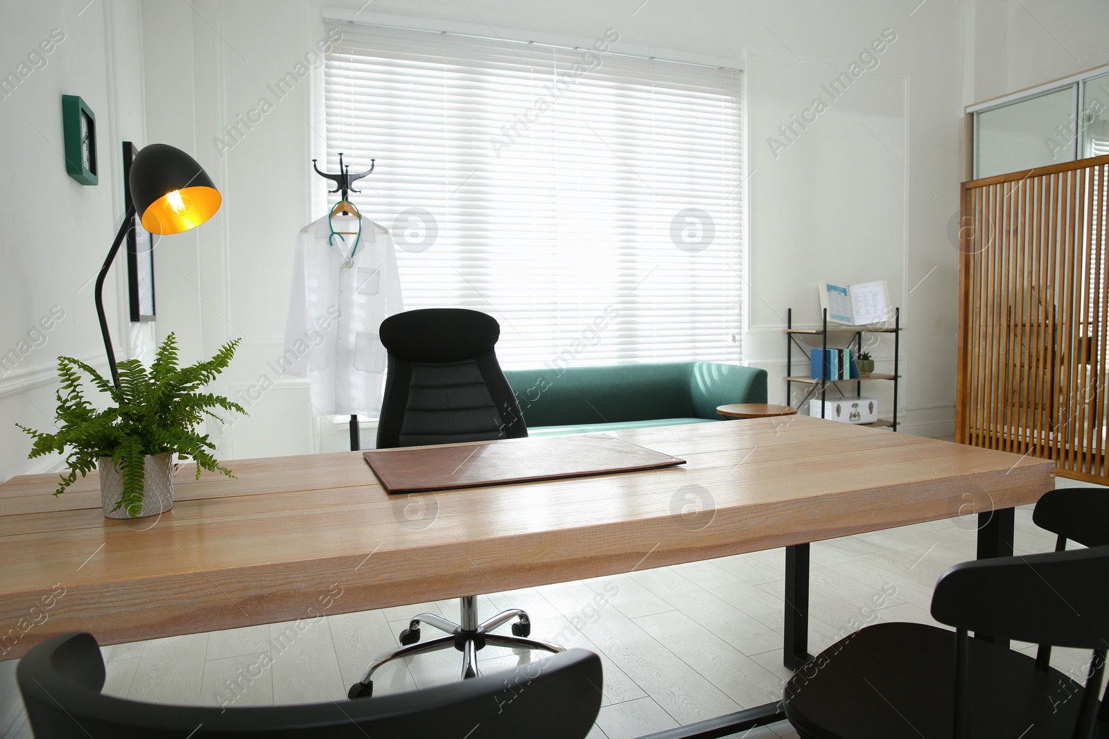 Photo of Modern medical office interior with doctor's workplace and sofa