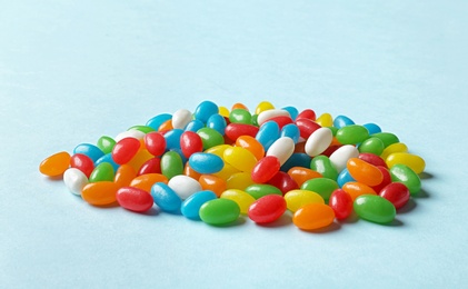 Delicious bright jelly beans on color background