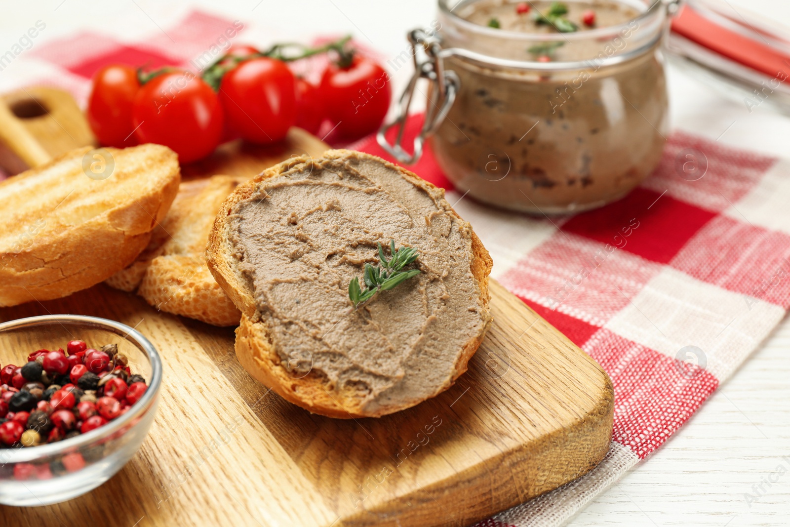 Photo of Fresh bread with delicious liver pate on white wooden table, closeup view