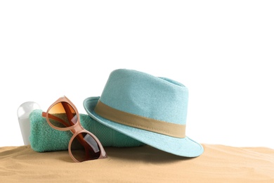 Photo of Composition with hat, beach sand and sunglasses on white background