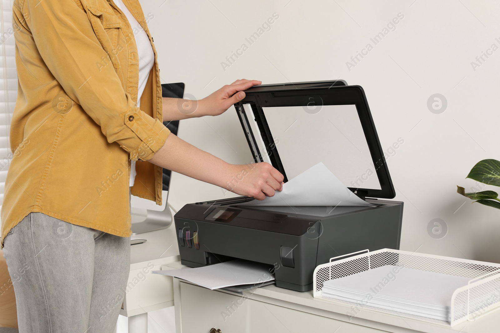 Photo of Woman using modern printer at home, closeup