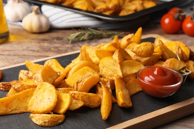 Photo of Delicious oven baked potatoes with sauce served on board