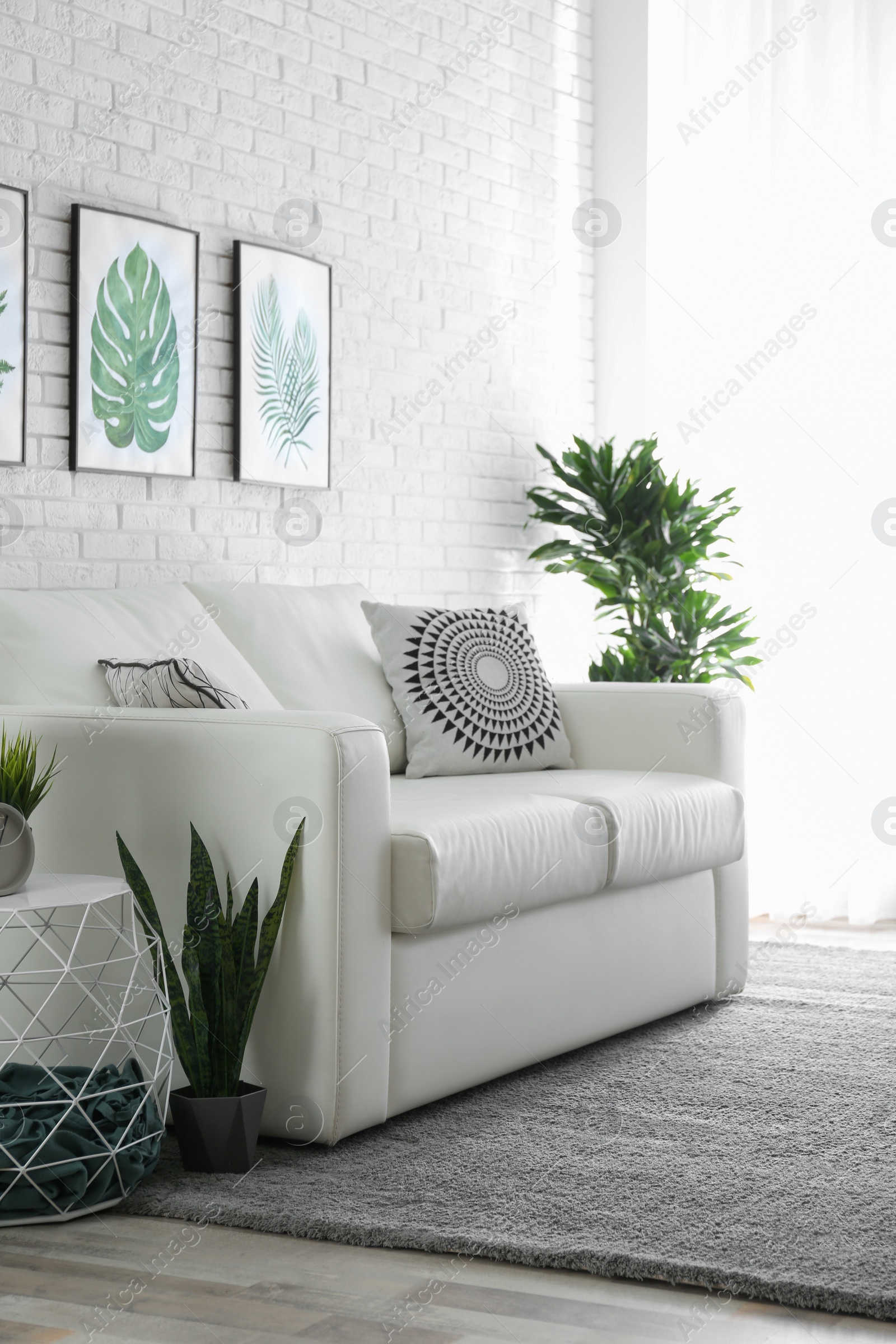 Photo of Comfortable white sofa in modern room. Interior design