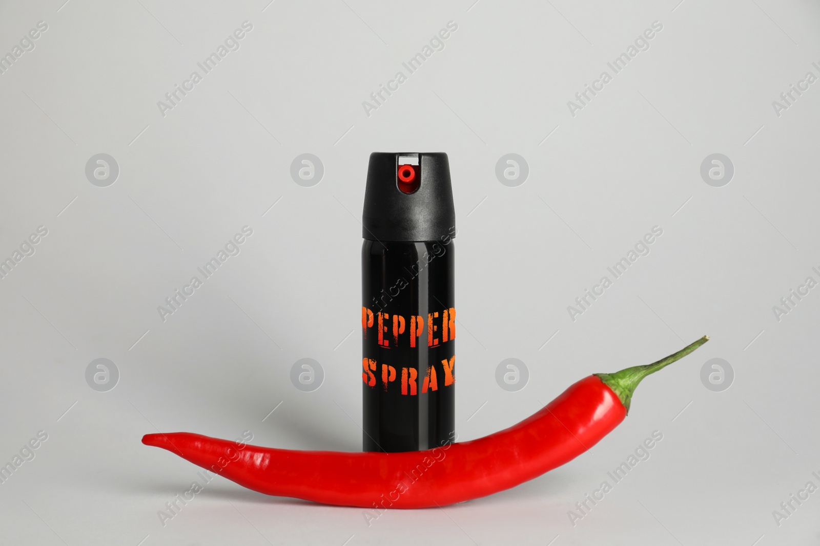 Image of Bottle of gas spray and fresh chili pepper on grey background