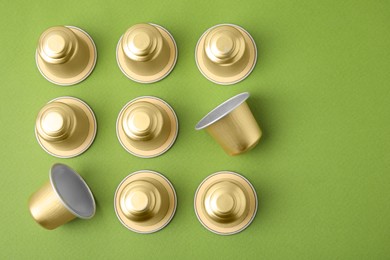 Photo of Many coffee capsules on green background, flat lay. Space for text