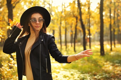 Beautiful happy woman walking in park on autumn day