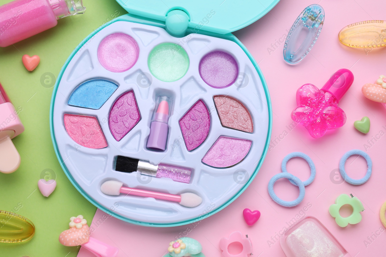 Photo of Eye shadow palette and other decorative cosmetics for kids on color background, flat lay