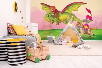 Image of Kid's room interior with bed and play tent. Fairytale themed wallpapers with knight, dragon and princess