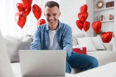 Photo of Valentine's day celebration in long distance relationship. Man chatting with his girlfriend at home