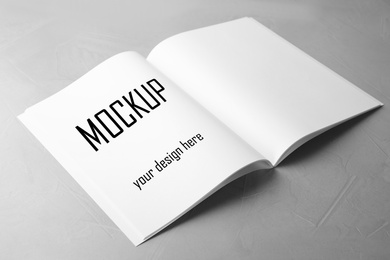 Text Mockup Your Design Here in open book on light grey stone background 