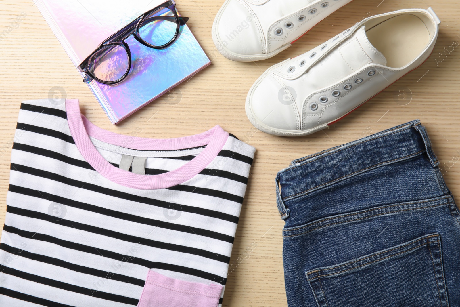 Photo of Flat lay composition with stylish clothes and notebook on wooden table. Fashion blogger