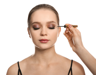 Photo of Artist applying makeup onto woman's face on white background
