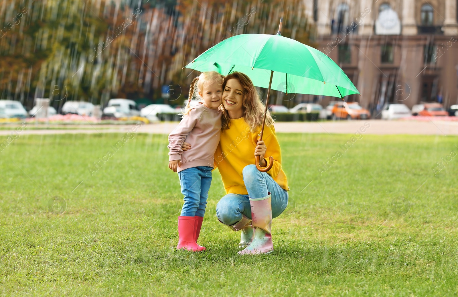 Photo of Happy mother and daughter with umbrella in park