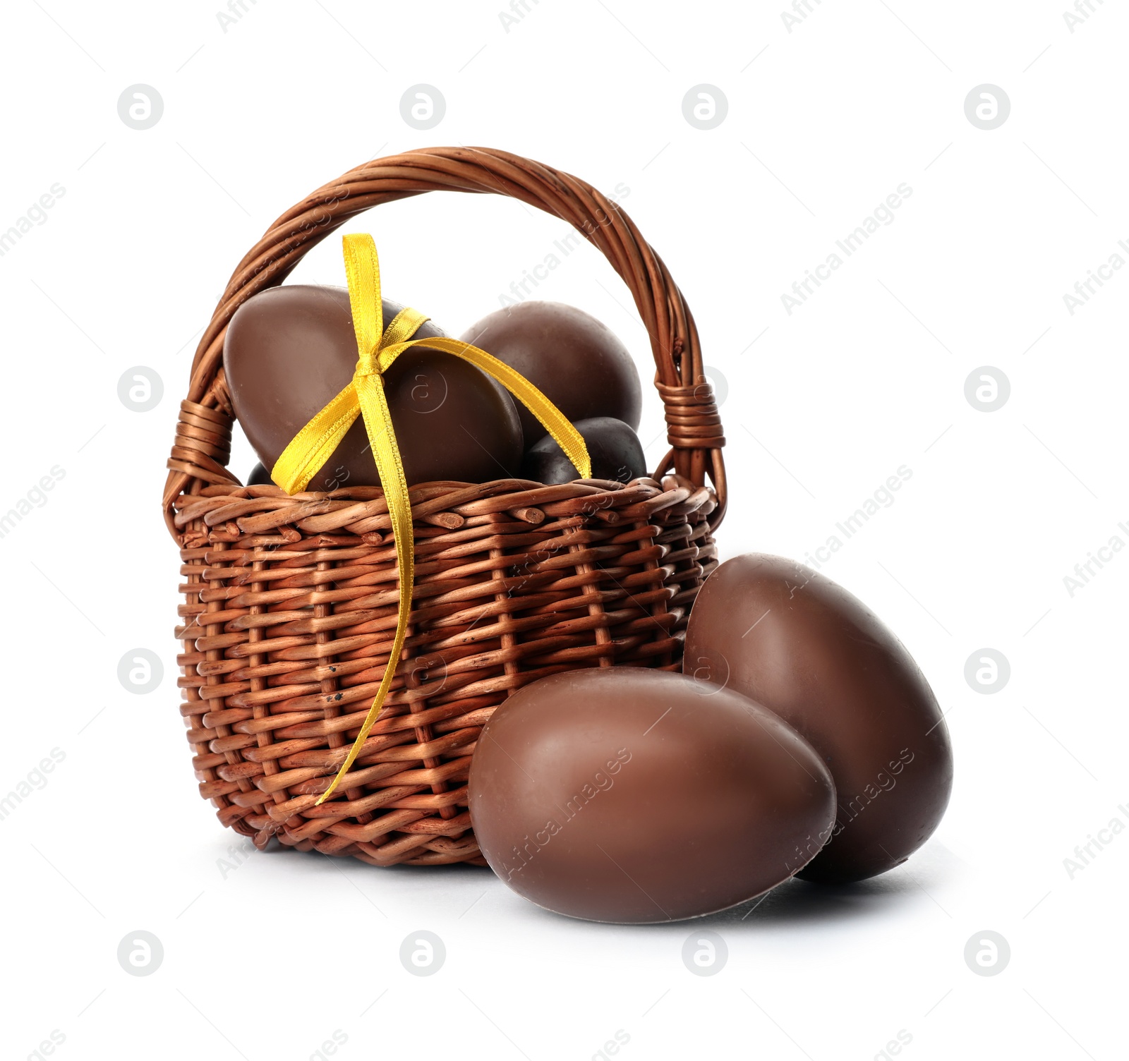 Photo of Wicker basket with sweet chocolate Easter eggs on white background