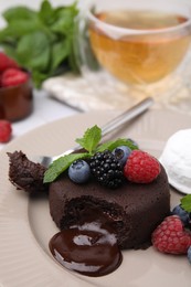 Photo of Delicious chocolate fondant served with fresh berries on table, closeup. Space for text