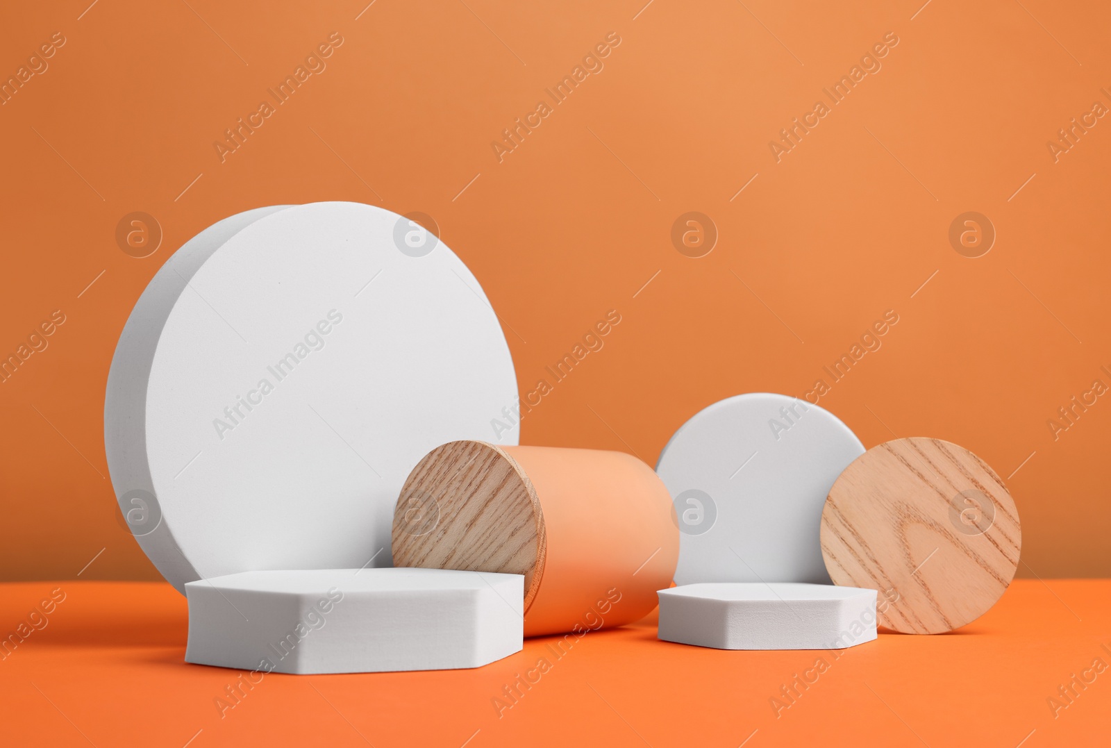 Photo of Scene for product presentation. Podiums of different geometric shapes on orange background