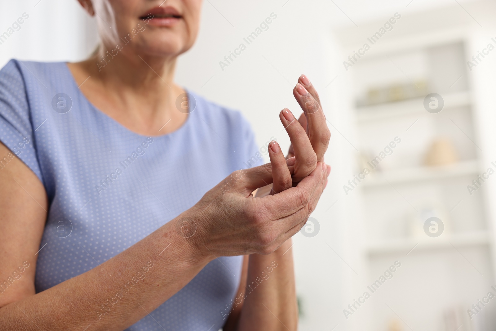 Photo of Arthritis symptoms. Woman suffering from pain in hand at home, closeup. Space for text