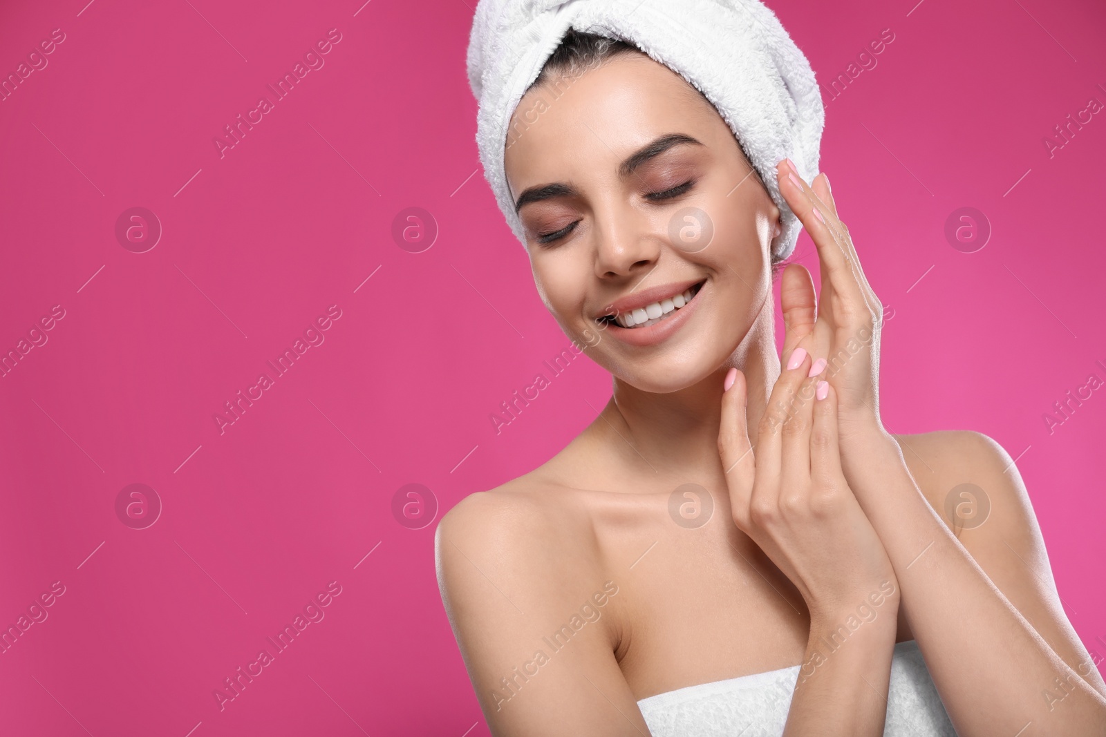 Photo of Happy young woman with towel on head against pink background, space for text. Washing hair