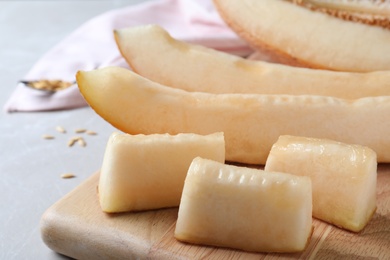 Photo of Sliced delicious ripe melon on grey marble table, closeup