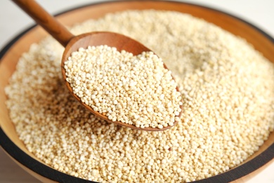 Photo of Spoon and bowl with white quinoa, closeup